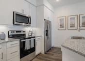 Thumbnail 8 of 43 - a kitchen with white cabinets and black appliances