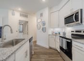 Thumbnail 6 of 43 - a kitchen with white cabinets and black appliances