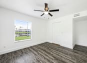 Thumbnail 35 of 42 - an empty living room with a ceiling fan and a window