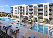Thumbnail 7 of 30 - A large apartment complex with a pool.
