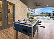 Thumbnail 15 of 30 - A foosball table is in the middle of a room with a pool table and a balcony.