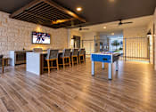 Thumbnail 14 of 30 - A room with wooden floors and a television mounted on a stone wall.