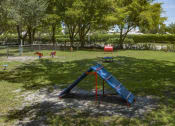 Thumbnail 32 of 52 - a swing set in a playground at a park