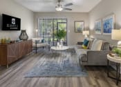 Thumbnail 9 of 52 - a living room with a couch and a table and a ceiling fan