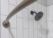 Thumbnail 15 of 48 - A shower head mounted on a white tiled wall.