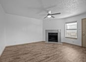 Thumbnail 20 of 43 - A room with a fireplace and a ceiling fan.