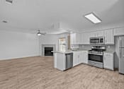 Thumbnail 17 of 43 - A spacious kitchen with a wood floor and white appliances.