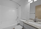 Thumbnail 31 of 43 - A white bathroom with a toilet, sink, and bathtub.