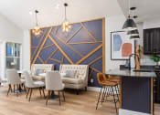 Thumbnail 13 of 28 - a living room with a dining room table and chairs and a kitchen area with a couch and