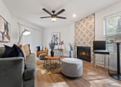 Thumbnail 5 of 28 - a living room with a fireplace and a ceiling fan