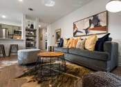 Thumbnail 1 of 28 - a living room with a gray couch and a round coffee table