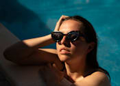 Thumbnail 18 of 19 - A person with sunglasses leaning on the edge of a pool.