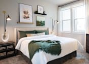 Thumbnail 14 of 44 - A bedroom with a large bed and a green throw blanket.