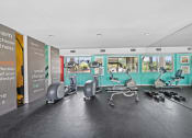 Thumbnail 8 of 17 - a gym with exercise machines and chairs in a large room with windows