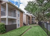 Thumbnail 20 of 24 - Apartment building with a green lawn in front.