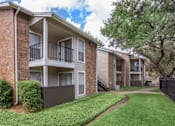 Thumbnail 21 of 24 - Apartment complex with a green lawn in front.