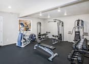 Thumbnail 11 of 24 - A spacious home gym with a variety of equipment including a treadmill, weights, and a bench press.