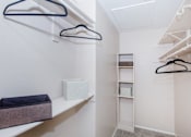 Thumbnail 5 of 24 - A white closet with a shelf and a purple storage bin.