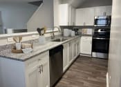 Thumbnail 1 of 36 - a kitchen with white cabinets and granite counter tops