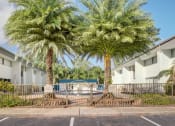 Thumbnail 12 of 18 - a building with palm trees and a pool in front of it