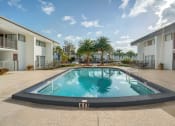 Thumbnail 17 of 18 - a pool in the middle of two apartment buildings with palm trees