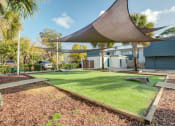 Thumbnail 14 of 18 - a backyard with a lawn and a shade sail