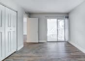 Thumbnail 8 of 18 - an empty living room with a door to a balcony