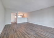 Thumbnail 6 of 18 - an empty living room with wood flooring and white walls