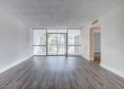 Thumbnail 7 of 18 - an empty living room with wood flooring and a balcony