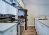 Thumbnail 5 of 18 - a kitchen with a stove and a sink and a refrigerator