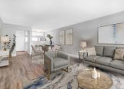 Thumbnail 1 of 18 - a living room with a couch and chairs and a dining room table