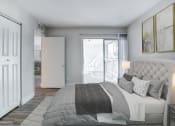 Thumbnail 4 of 18 - a bedroom with a bed and a door to a balcony