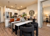 Thumbnail 1 of 30 - A modern kitchen with a dining table and chairs.