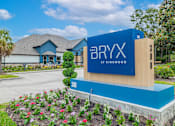 Thumbnail 39 of 39 - A blue and wooden sign for The Bryx at Kingwood stands in front of a house.