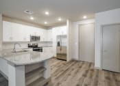 Thumbnail 2 of 22 - a kitchen with white cabinets and stainless steel appliances
