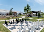 Thumbnail 29 of 30 - A giant chess set is set up on a grassy area.