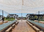 Thumbnail 27 of 30 - A covered walkway with benches and a canopy.