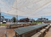 Thumbnail 24 of 30 - a picnic area with benches and a table under an umbrella