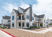 Thumbnail 1 of 30 - A modern house with a white exterior and black roofing.