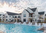 Thumbnail 25 of 38 - A large white building with a pool in front.