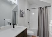 Thumbnail 12 of 30 - A bathroom with a white countertop and a white tiled wall.