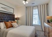 Thumbnail 10 of 30 - A bedroom with a large bed and a painting above it.