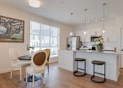Thumbnail 6 of 30 - A kitchen with a bar and chairs.