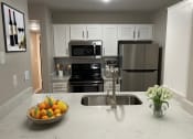 Thumbnail 11 of 22 - a kitchen with stainless steel appliances and a bowl of fruit
