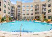 Thumbnail 17 of 22 - a swimming pool with an apartment building in the background