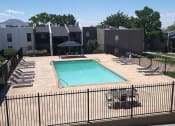 Thumbnail 10 of 11 - a pool with a fence around it and a building in the background