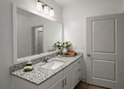 Thumbnail 29 of 41 - A bathroom with a sink, mirror, and a vase of flowers.