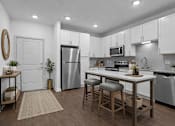 Thumbnail 20 of 41 - A kitchen with white cabinets and a wooden island.