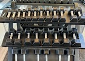 Thumbnail 19 of 41 - A set of dumbbells on a rack in a gym.