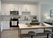 Thumbnail 23 of 41 - A modern kitchen with a refrigerator, microwave, oven, and sink.